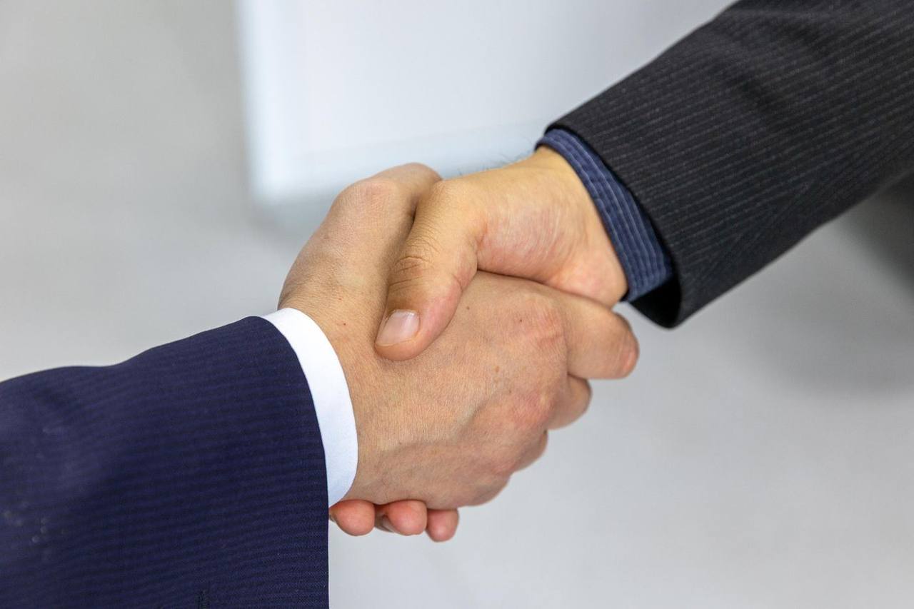 Two professionals shaking hands over a business agreement